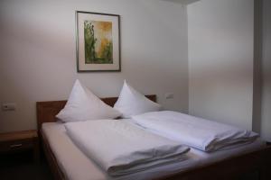 加尔盖伦Familienhotel Mateera Gargellen / Montafon的一张带白色床单和枕头的床