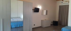 比亚恩科Villaggio Jonio Blu的客房设有带一张床和镜子的卧室