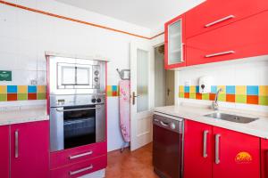 加的斯Martinez by Cadiz Time的一间带红色橱柜和水槽的厨房