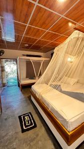 阿鲁甘湾Hakuna Matata Arugambay的一间卧室配有一张带蚊帐的床