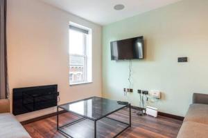 赫尔Smart 2 Bed Apartment with Parking in Central Hull的客厅配有玻璃咖啡桌和电视
