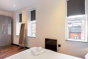 赫尔Smart 2 Bed Apartment with Parking in Central Hull的卧室配有白色的床和2扇窗户。
