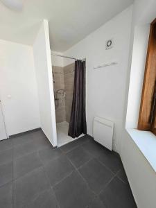 FromellesGite canard的带淋浴的浴室和瓷砖地板。