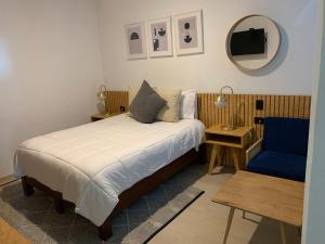 乔卢拉CHOLULA SUITES的一间卧室配有一张床和一张蓝色椅子