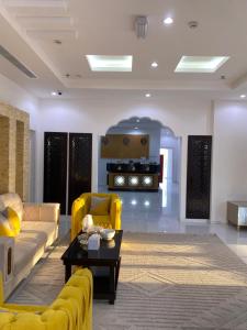 FirqANTIKA HOTEL / انتيكا للشقق الفندقيه的客厅配有黄色的沙发和桌子