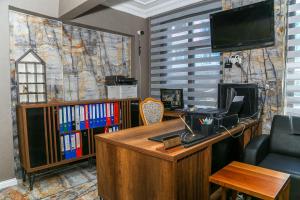 伊斯坦布尔阿西丁生活酒店的办公室设有一张桌子、一台电脑和一台电视机