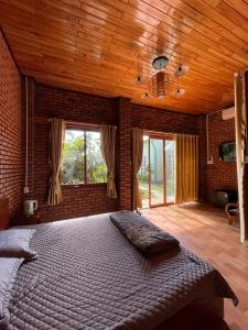 Kon Tum Kơ PangMộc House的一间卧室设有一张带木制天花板的大床