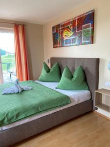 韦因地区拉奇Zweytick Gästezimmer Weingut的一间卧室配有一张带绿色枕头的大床