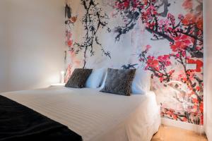 锡罗洛Tra gli Alberi e il Mare的一间卧室配有一张带花卉墙壁的床