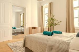 多瑙河畔克雷姆斯Deluxe Apartments near the center的白色卧室,床上配有两个绿色枕头