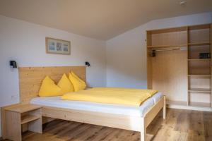 雷西亚Residence Montana的一间卧室配有一张带黄色枕头的床