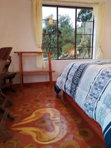 Comunidad ChallapampaECO CABAÑA INTIWAT'A的一间卧室设有一张床和一个窗口