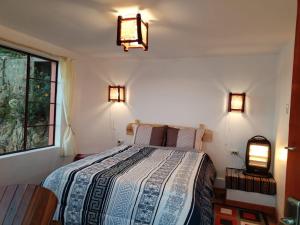Comunidad ChallapampaECO CABAÑA INTIWAT'A的卧室配有一张床,墙上有两盏灯