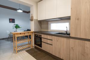 卡塔尼亚Maioliche Apartment的厨房配有木制橱柜、水槽和桌子