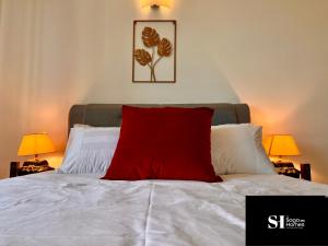 吉隆坡Cityscape Retreat for Urban Adventure by Cowidea的白色床上的红色枕头和两盏灯