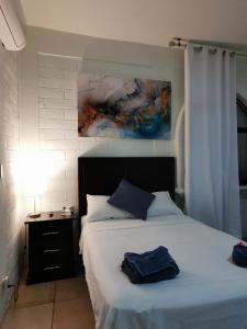 帕伦克Mitico El Castillo的卧室配有一张床,墙上挂有绘画作品