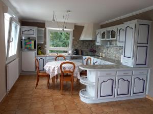 克罗宗Néo-bretonne Presqu'íle de Crozon-Morgat, proche de la mer的厨房配有白色橱柜和桌椅