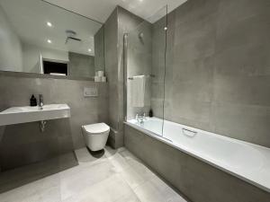 卡迪夫卡迪夫公寓酒店的一间带水槽、浴缸和卫生间的浴室
