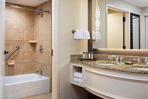 格雷普韦恩盖洛德得克萨斯度假及会议中心酒店的一间带水槽、浴缸和镜子的浴室