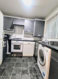 IdleHigh Rigg House Bradford - Luxury Accomodation with Private Parking的厨房配有洗衣机和洗衣机。