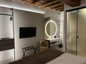 罗马Affreschi al Pantheon的一间卧室配有一张床、镜子和电视