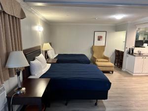 兰利Travelodge by Wyndham Langley的酒店客房,配有两张床和椅子