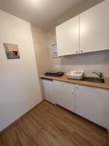 鲁斯特玛丽安娜膳食公寓酒店的小厨房配有白色橱柜和水槽