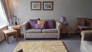 佩文西Cromarty Cottage Eastbourne的客厅配有带紫色和黄色枕头的沙发
