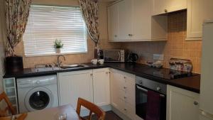 佩文西Cromarty Cottage Eastbourne的厨房配有水槽和洗衣机