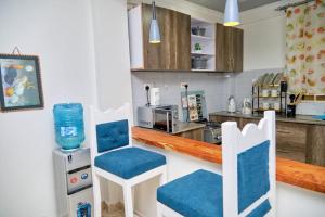 纳纽基Olivet Homes的厨房配有蓝白色椅子和柜台