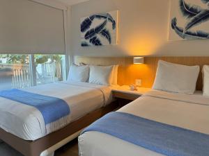 基拉戈吉尔伯特度假酒店的酒店客房设有两张床和窗户。