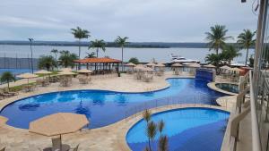 巴西利亚Premier Residence的享有带桌子和遮阳伞的游泳池的景色