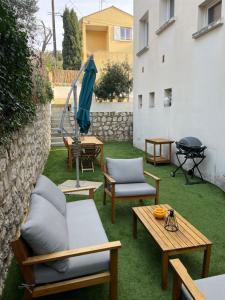 锡富尔勒普拉日Studio avec jardin proche plage Six Fours/Sanary的一个带桌椅和烧烤架的庭院