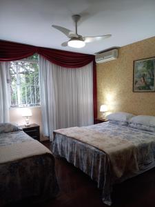 巴西利亚KzaZenDF CamaeCafé AsaSul的酒店客房配有两张床和吊扇。