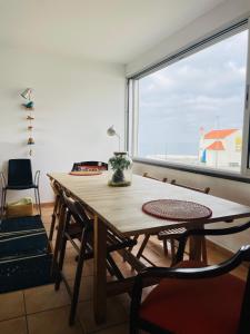 赞布热拉-杜马尔Sunset Beach House的配有大窗户的客房内的桌椅
