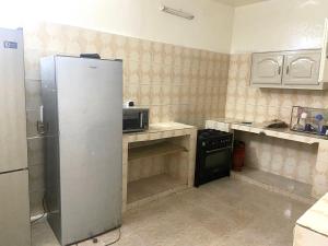 达喀尔Villa L6的厨房配有冰箱和炉灶。