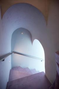 费拉EDGE ON VOLCANO SUITES的白色墙壁上拱门的楼梯