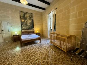 维多利亚Tal-Kaptan的卧室配有一张床,墙上挂有绘画作品