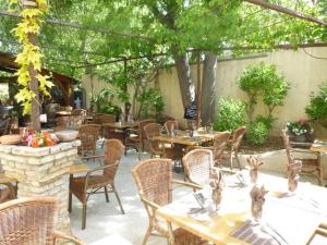 弗尔东河畔维农圆桌宾馆的户外庭院配有桌椅和树木。
