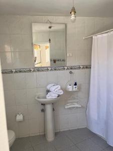 科皮亚波Hostal Villa Italo的一间带水槽、镜子和卫生间的浴室