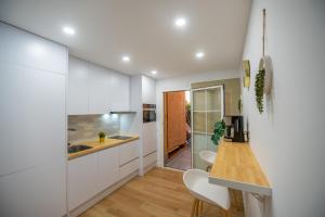 马拉加PRENSA的厨房配有白色橱柜和木台面
