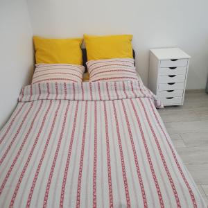 华沙Krucza Apartament的一张带条纹床单和黄色枕头的床