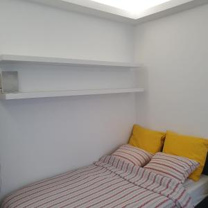 华沙Krucza Apartament的白色客房的一张床位,配有黄色枕头