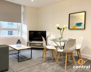 邓迪1 Bedroom Apartment by Central Serviced Apartments - Modern - FREE Street Parking - Close to University of Dundee - Weekly-Monthly Stay Offers - Wi-Fi - Cosy Little Apartment的客厅配有桌椅和电视。