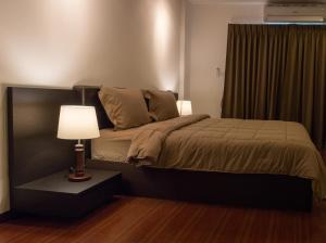 芭堤雅市中心疗养地酒吧及旅馆的一间卧室配有一张带灯和窗户的床
