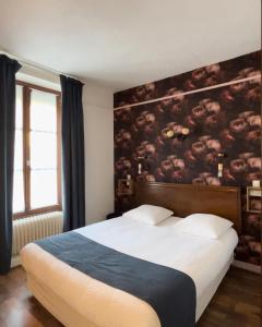 La Chapelle-MontligeonLogis- Hôtel & Restaurant Le Montligeon的卧室配有一张大床,墙上挂有绘画作品