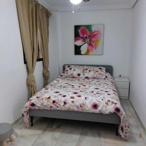 科尔多瓦El Patio de Lola的一间卧室配有一张带花卉图案的被子的床