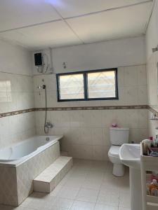 DompoasiInviting 3-Bed Apartment in Kumasi Ashanti Ghana的带浴缸、卫生间和盥洗盆的浴室