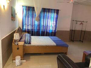 DompoasiInviting 3-Bed Apartment in Kumasi Ashanti Ghana的小卧室配有一张带蓝色窗帘的床