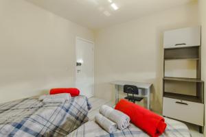 新汉堡市Apartamento 2 dormitorios Novo Hamburgo Espaço Namibe的一间卧室配有一张带红色枕头的床和一张书桌